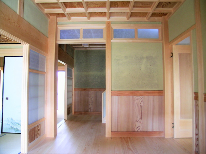 ホール。左へ和室、右へリビング、正面奥は2階への階段へと進みます。壁は昔からの土壁で土自体が湿度を調整し家の揺れを防ぐ効果があります。